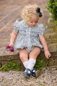 Little English classic children's clothing.  Dressy peter pan bubble for baby girls in blue Wisteria Floral with puff sleeves, ruffle details, and smocking at chest.