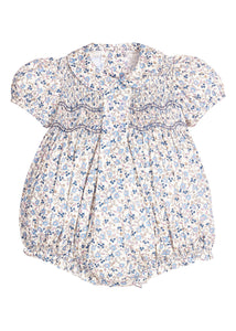Little English classic children's clothing.  Dressy peter pan bubble for baby girls in blue Wisteria Floral with puff sleeves, ruffle details, and smocking at chest. Paired with white cotton knee high socks with navy bow embroidery