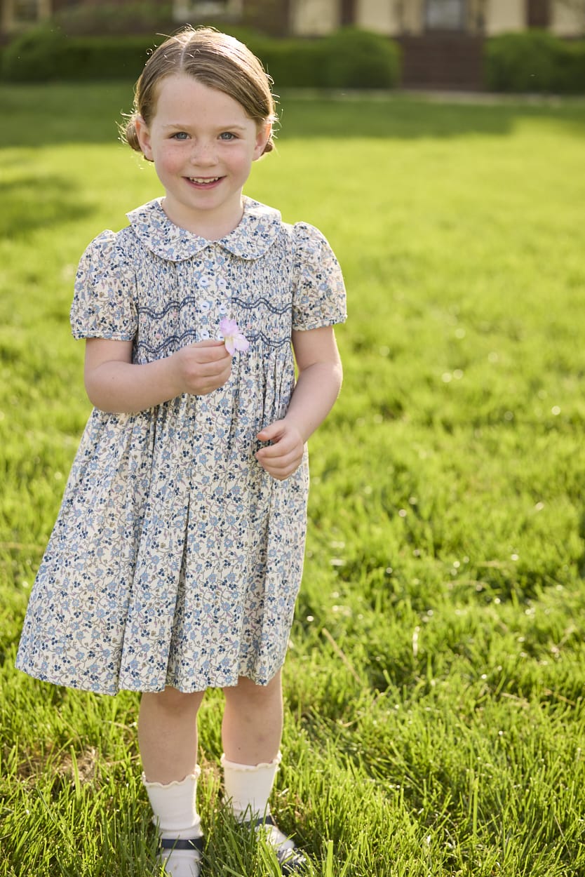 Little English traditional children's clothing. Capped sleeve blue, brown, and cream floral smocked dress with peter pan collar for little girls.