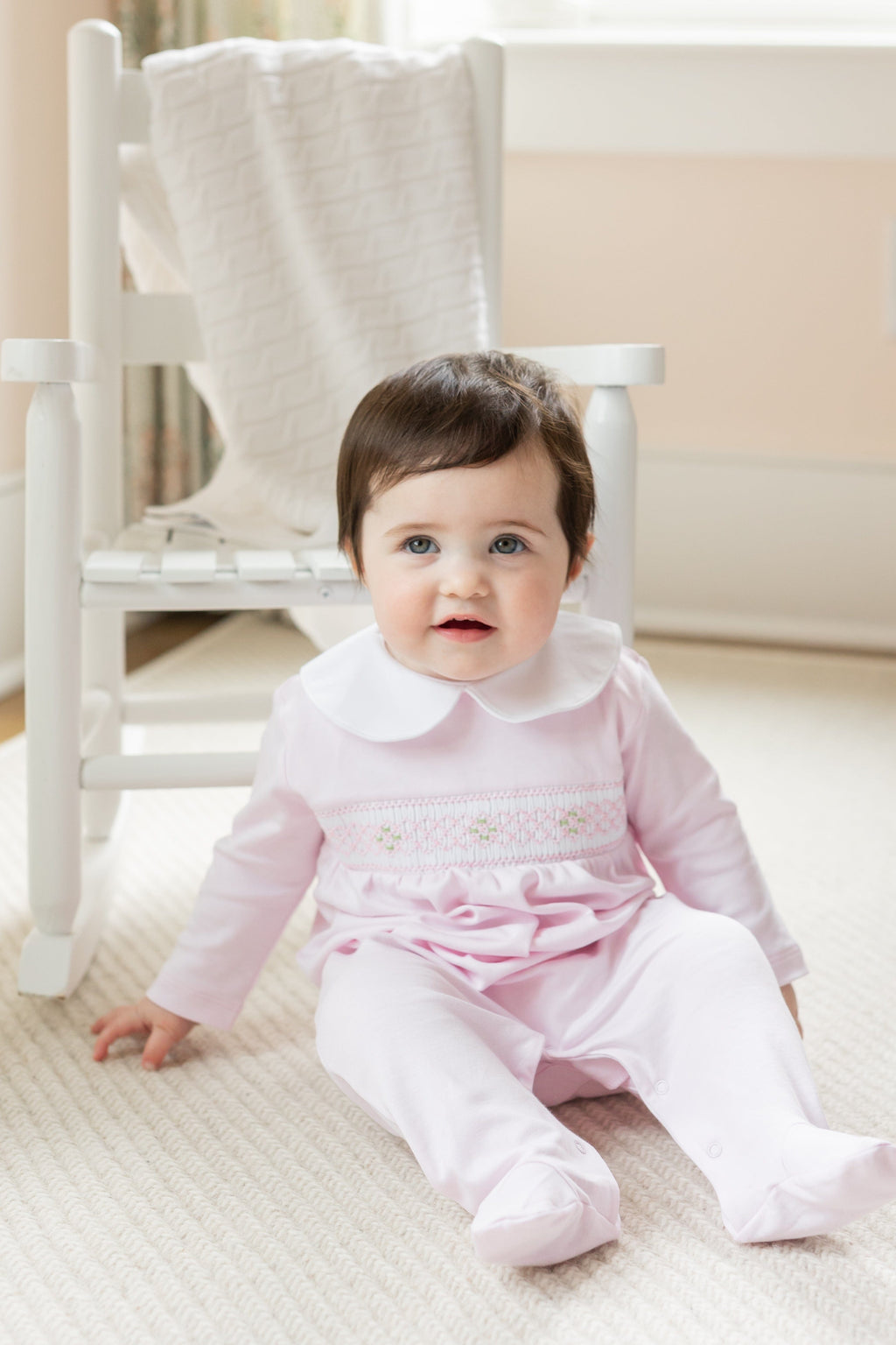 little english baby girl smocked footie with pink geo design and white peter pan collar