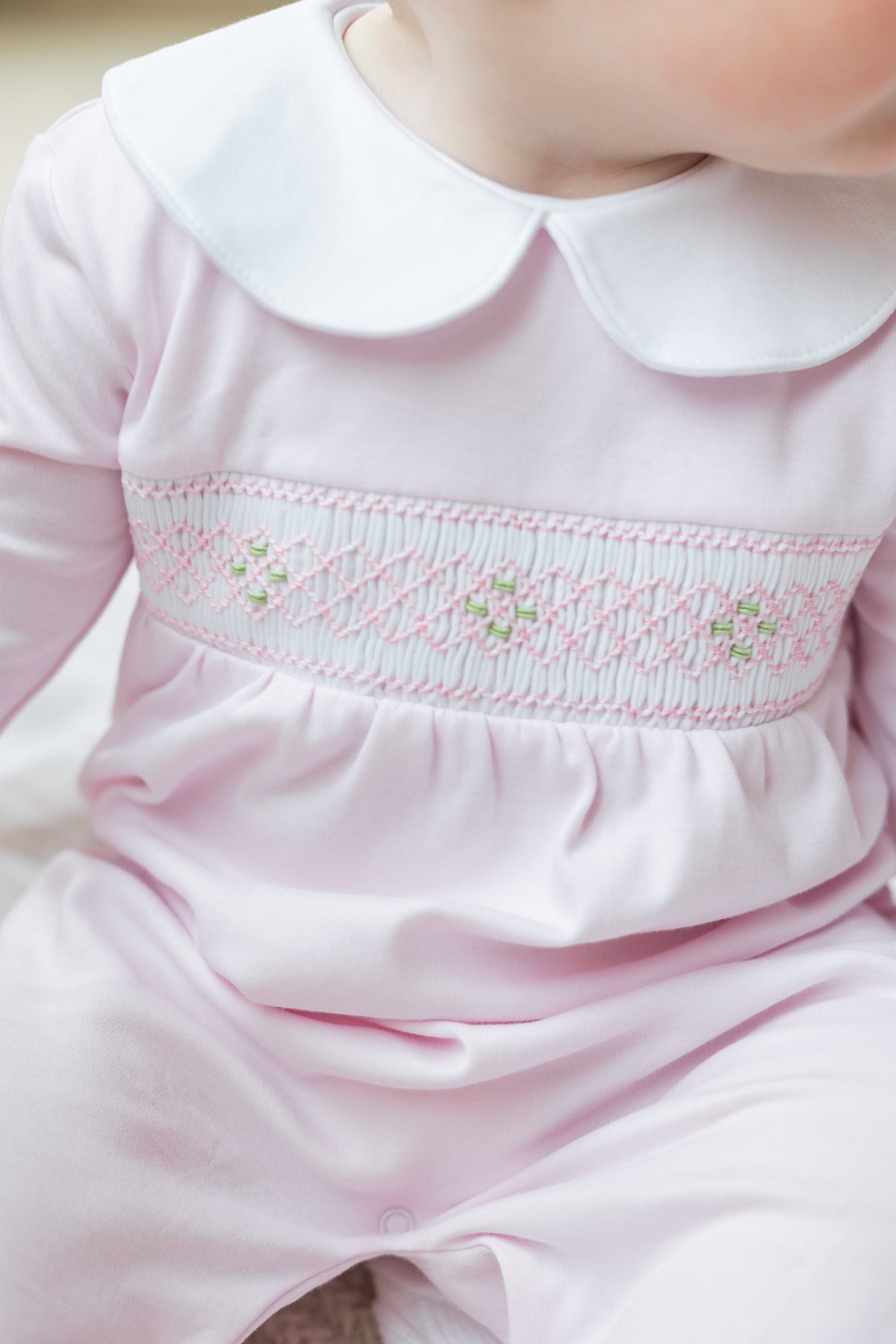 little english baby girl smocked footie with pink geo design and white peter pan collar