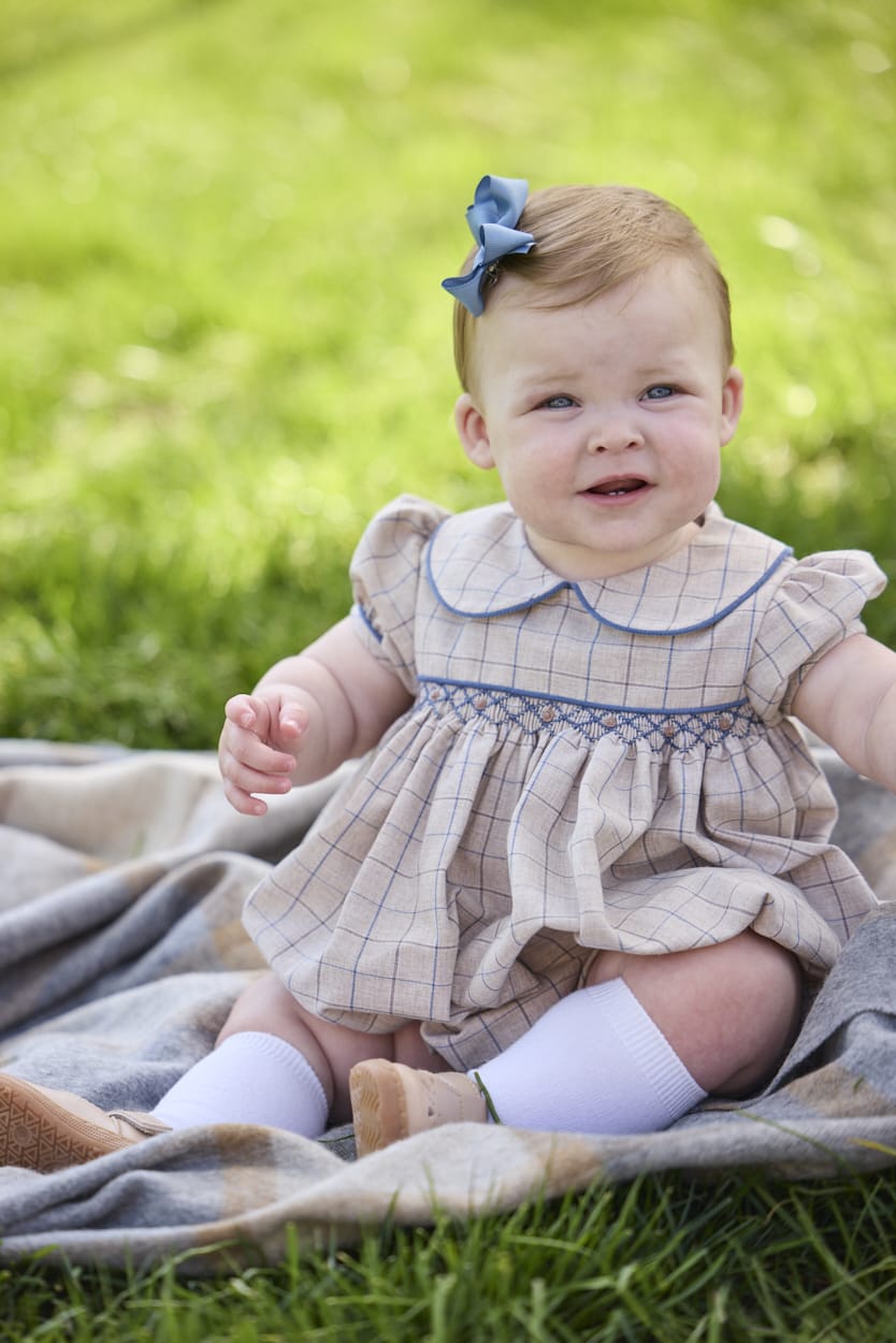 Little English classic children's clothing.  Smocked peter pan bubble in tan and blue Durham windowpane with puff sleeves and blue piping for baby girls