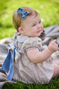 Little English classic children's clothing.  Smocked peter pan bubble in tan and blue Durham windowpane with puff sleeves and blue piping for baby girls