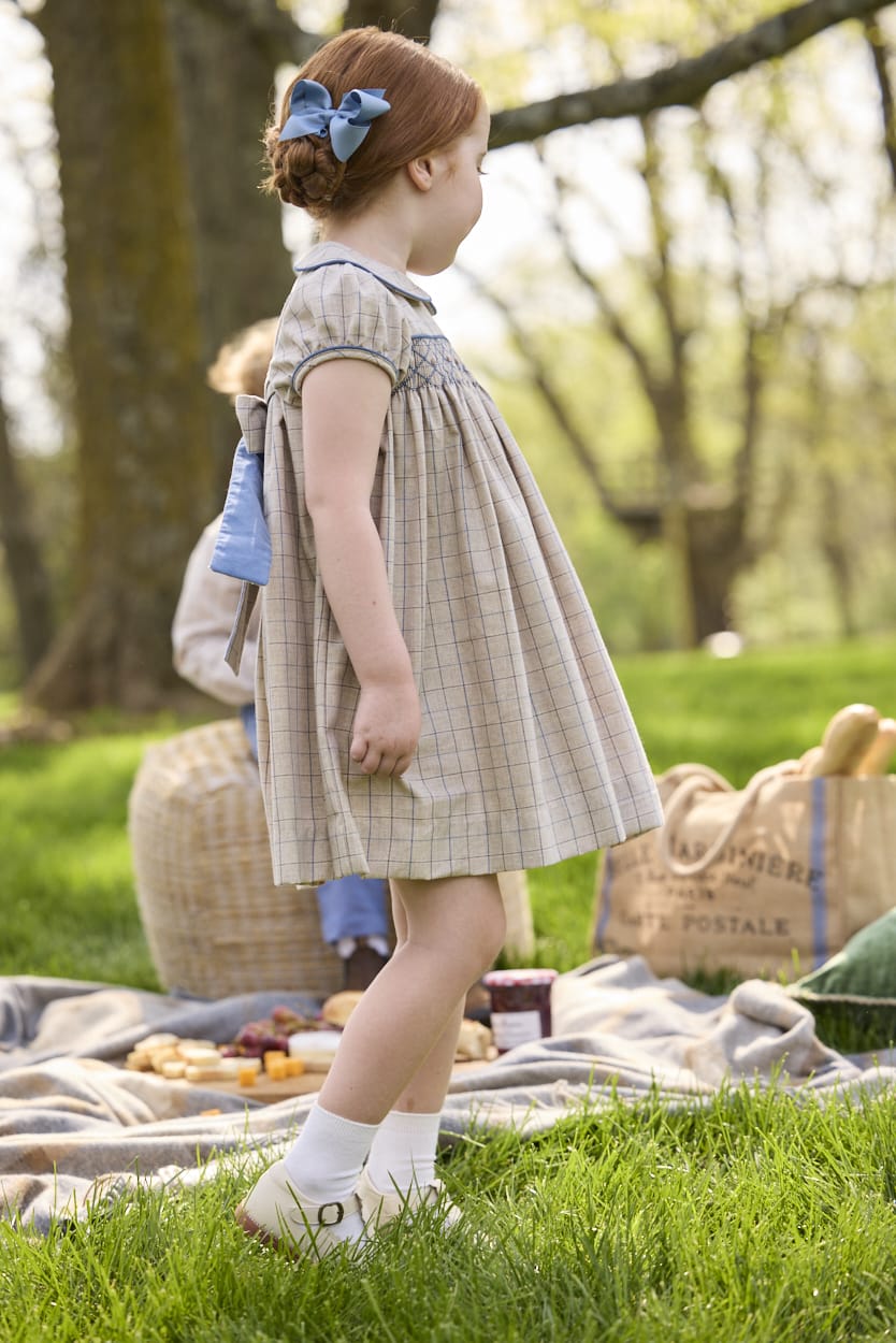 Little English traditional children's clothing.  Smocked peter pan dress in tan and blue Durham Windowpane with capped sleeves for toddler girls