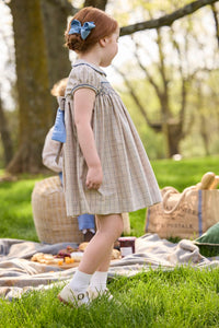 Little English traditional children's clothing.  Smocked peter pan dress in tan and blue Durham Windowpane with capped sleeves for toddler girls