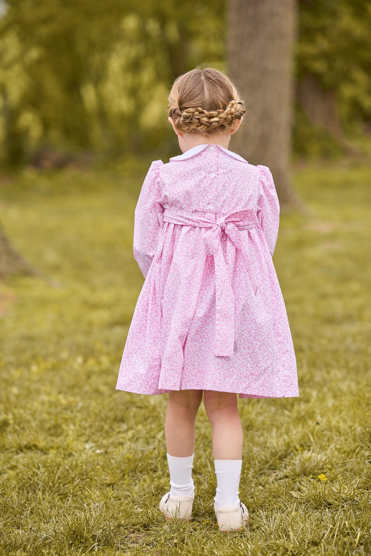 little english classic children's clothing girls pink and white floral long sleeve dress with peter pan collar, chest smocking, and bow embroidery for fall 