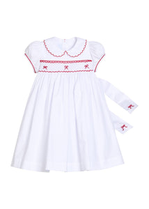Little English traditional children's clothing.  Puff sleeve white peter pan dress with scalloped collar, red trim, and bow smocking across the chest.  Dressy outfit for little girls for the holiday