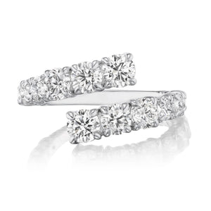 The Graduated Round Diamond Wraparound Ring in White Gold showcases two rows of G-H color round diamonds set side by side, overlapping at the ends, and is displayed on a reflective white surface.
