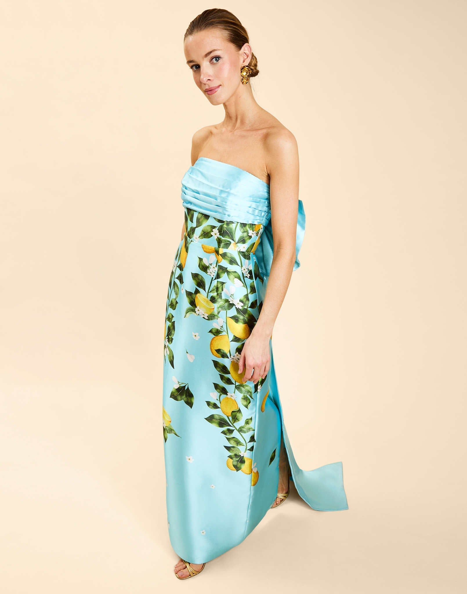 Solstice Gown in Sorrento Citrus poly silk twill with strapless neckline, removable bow, convertible bodice, and side pockets.