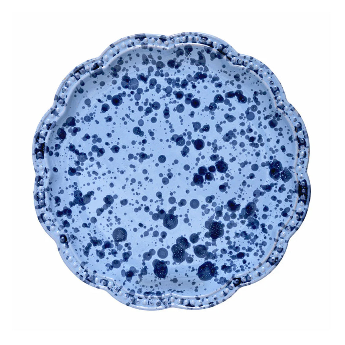 Top-down view of speckled blue dinner plate showcasing scalloped edge and dark navy splatter pattern on white background