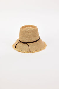 Beige straw bucket hat with a black band on a light beige background
