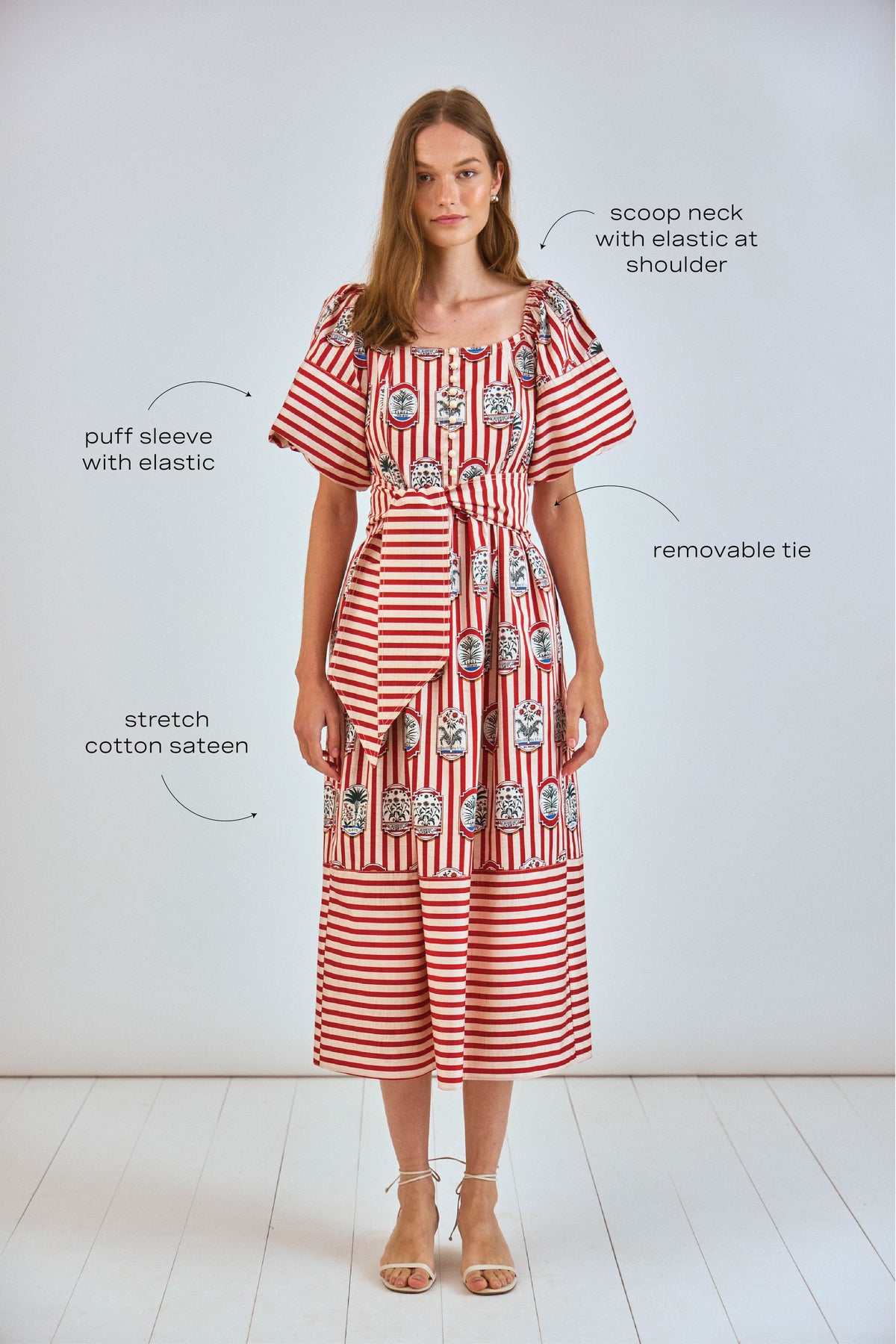 The Lucy midi dress has a square scoop neck, puff sleeves, front button placket, and a self belt.