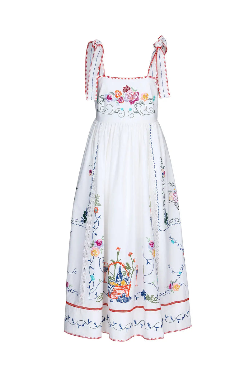 The Stefy Dress has tie straps, an empire waist, colorful embroidery, lace trim, and stitch edging.