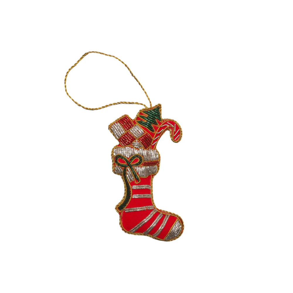 Front view of red velveteen stocking ornament with gold thread and beads, filled with gift and candy cane on white background