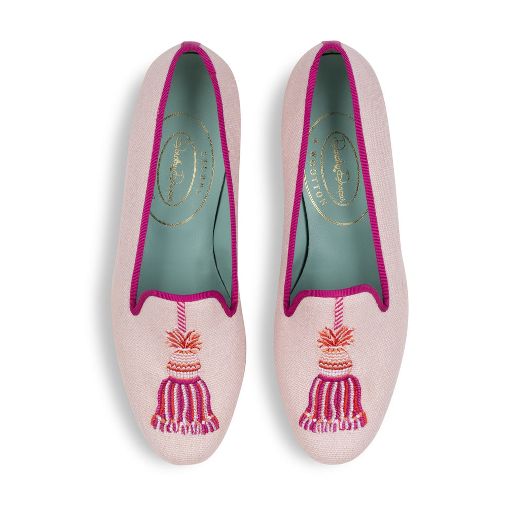 Top view of Tassel Blush linen slippers showcasing embroidered tassels, fuchsia trim, and teal leather lining on white background