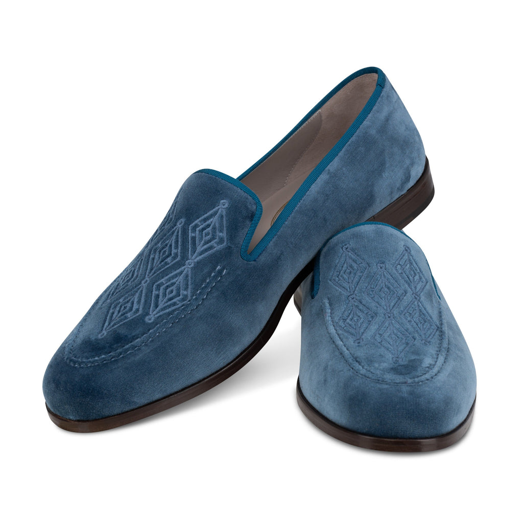 Angled view of Men’s Lattice Ink Venetian loafers showcasing navy velvet, grosgrain trim, and lattice embroidery on white