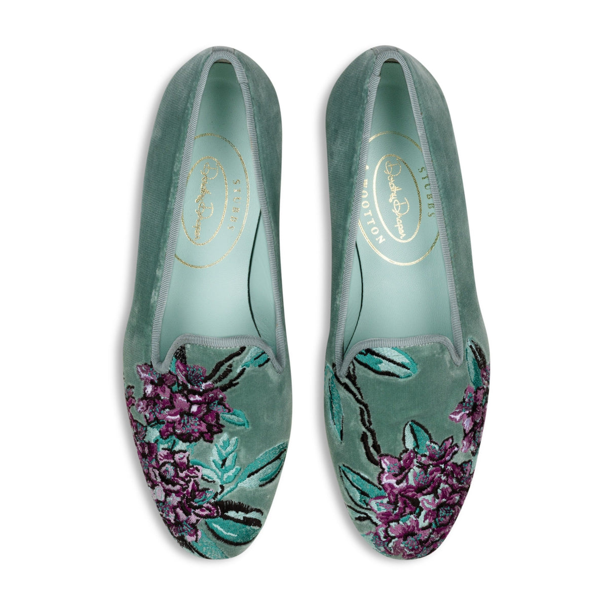 Top view of pair of Rhododendron Mint velvet slippers showcasing purple rhododendron embroidery and mint insoles on white background