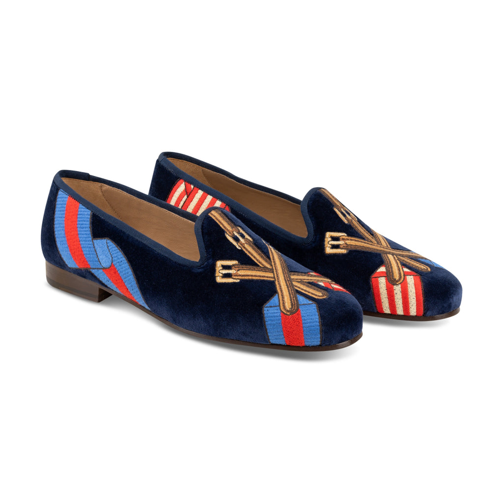 View of the Paddock Naval Slipper showing navy velvet and crossed tack embroidery over striped racing silks on white background