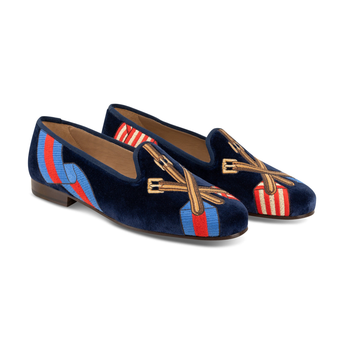 View of the Paddock Naval Slipper showing navy velvet and crossed tack embroidery over striped racing silks on white background