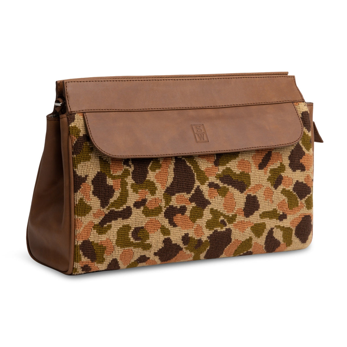 Three-quarter view of Hidden Dune Needlepoint Traveler showing brown leather flap and duck camo needlepoint body on white background