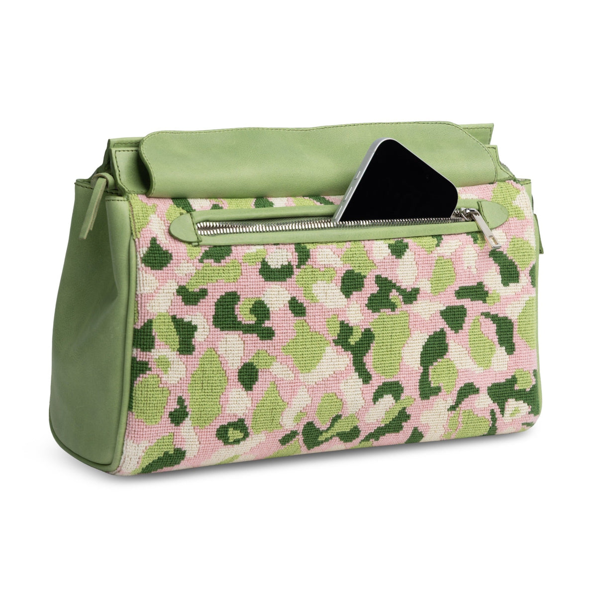 Three-quarter view of Hidden Palm Needlepoint Traveler showcasing pink and green camouflage needlepoint and front pocket on white background