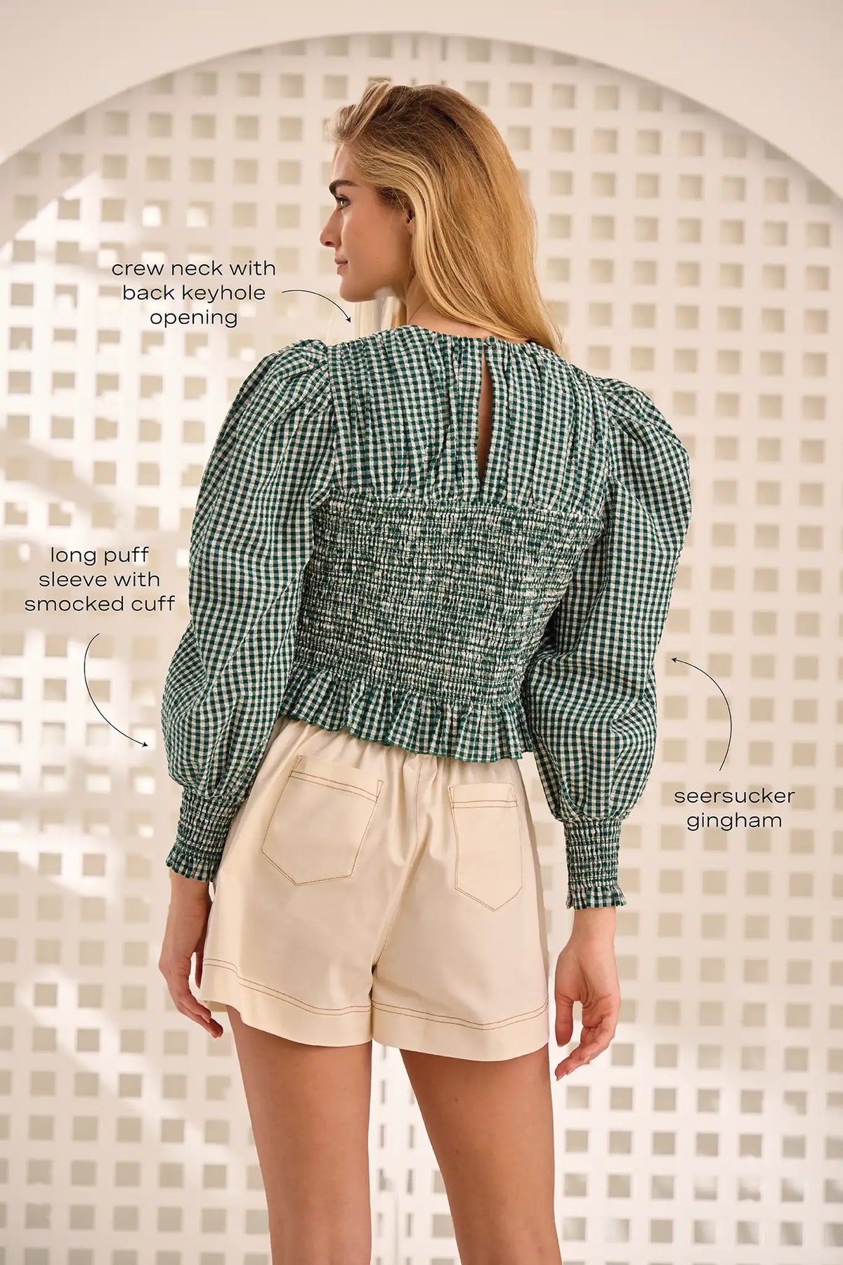 The Eubanks Top has a fitted bodice, puff sleeves, smocked cuffs, shirred yoke, and purl edge trim.
