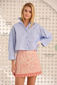 The Clarke Shirt has a cropped, boxy fit, a collared neckline, a button front and wide sleeves.
