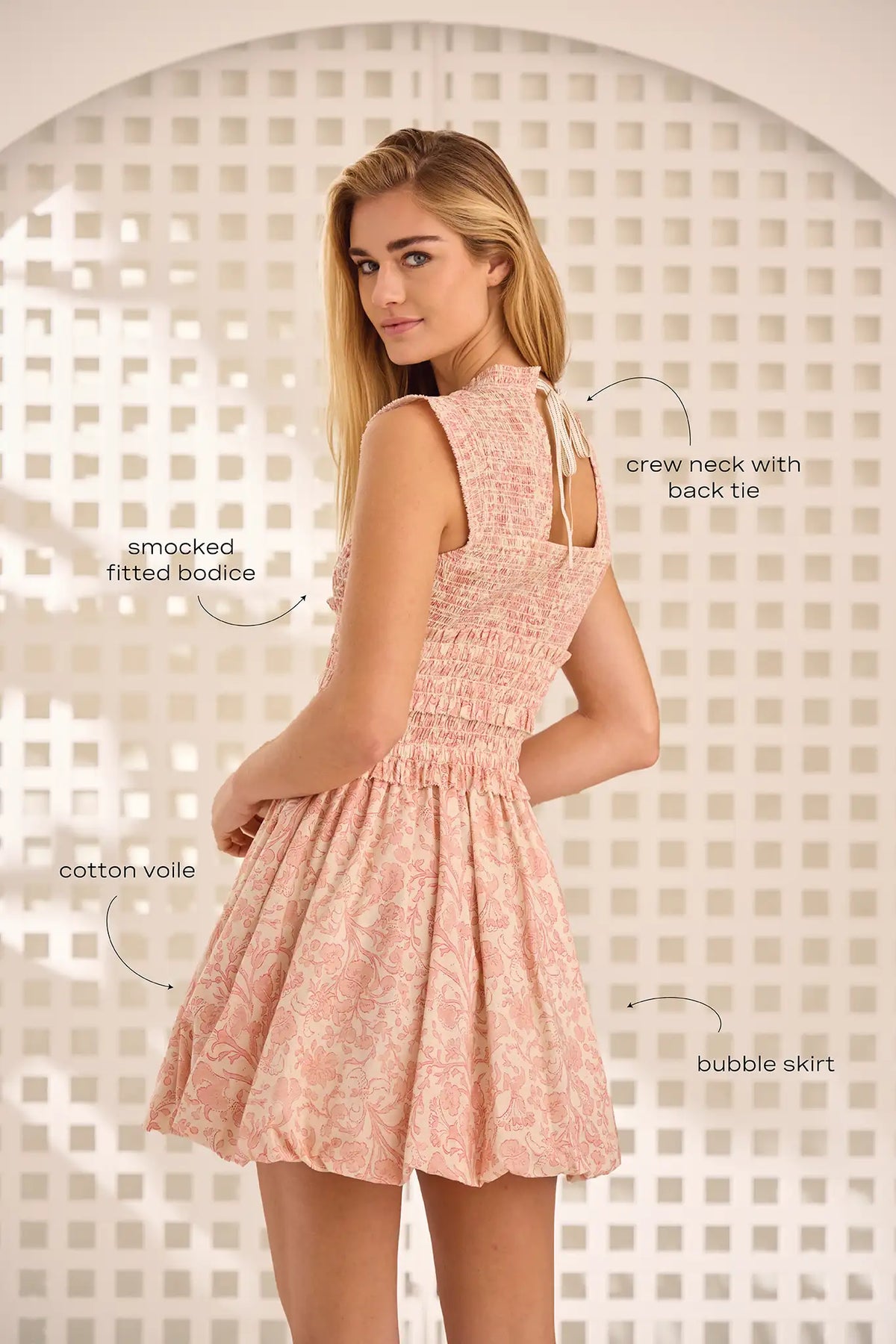 The Anita Dress has a diamond-smocked bodice, flutter cap sleeves, a back tie, and a bubble skirt.