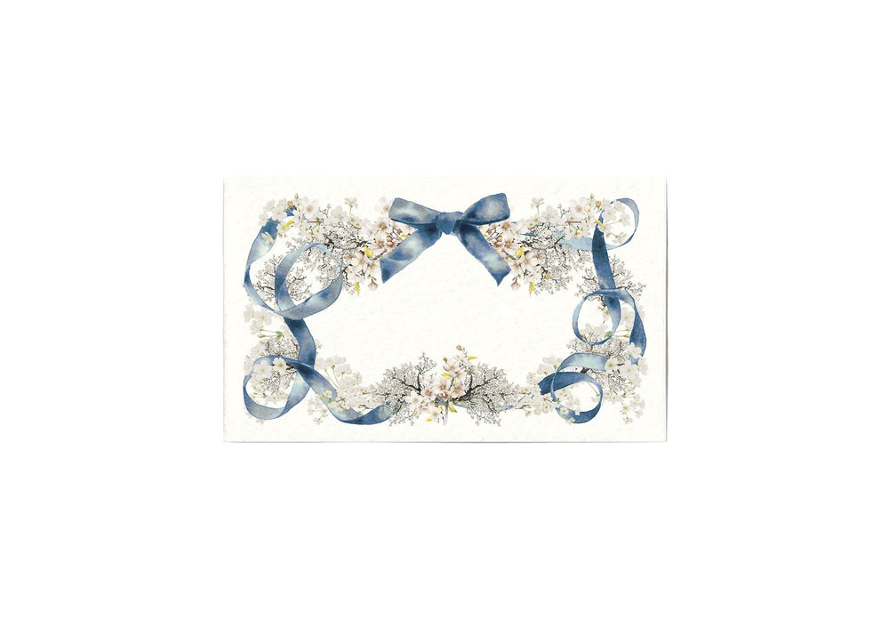 Front view of Swan Lake place card showcasing blue ribbon and delicate white floral border on textured ivory background