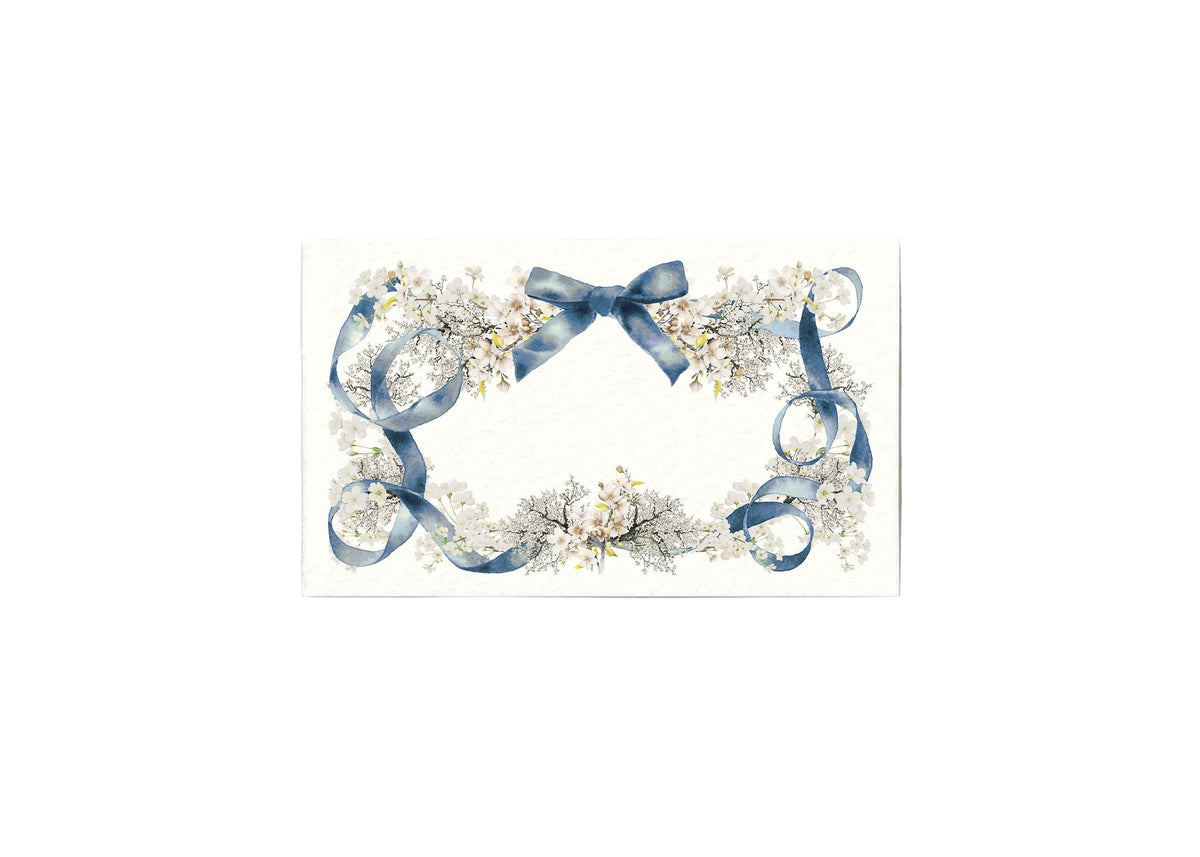 Front view of Swan Lake place card showcasing blue ribbon and delicate white floral border on textured ivory background