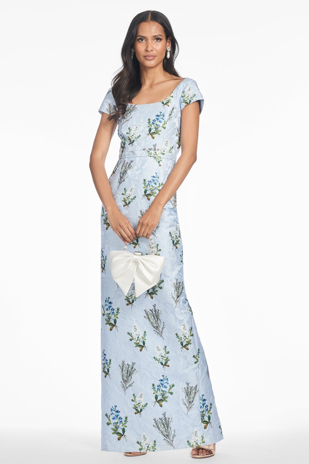 Front view of Grace Gown in Cloud Blue Panicle showing printed cloque and cap sleeves on model against white background