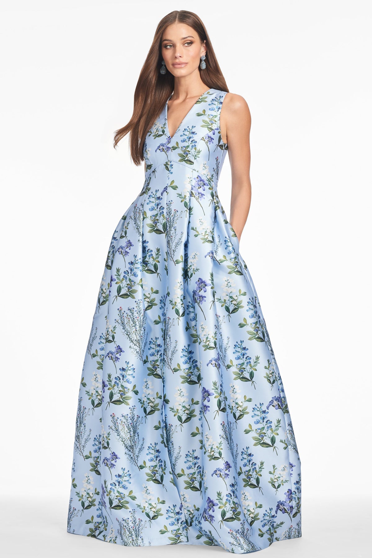Front view of Brooke Gown in Freesia Forest showing V neckline and floral box pleated skirt on model, white background