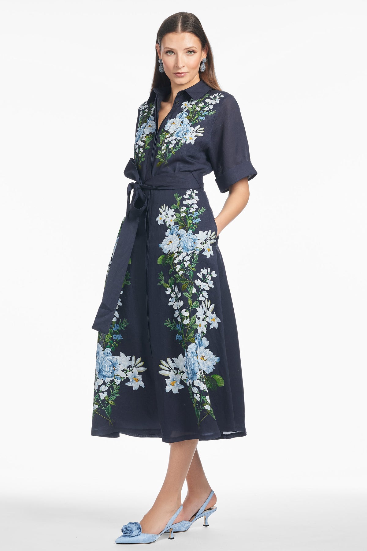 Three-quarter view of Joy Dress in Midnight Garden, navy midi shirt dress with blue floral print, tie waist and pockets