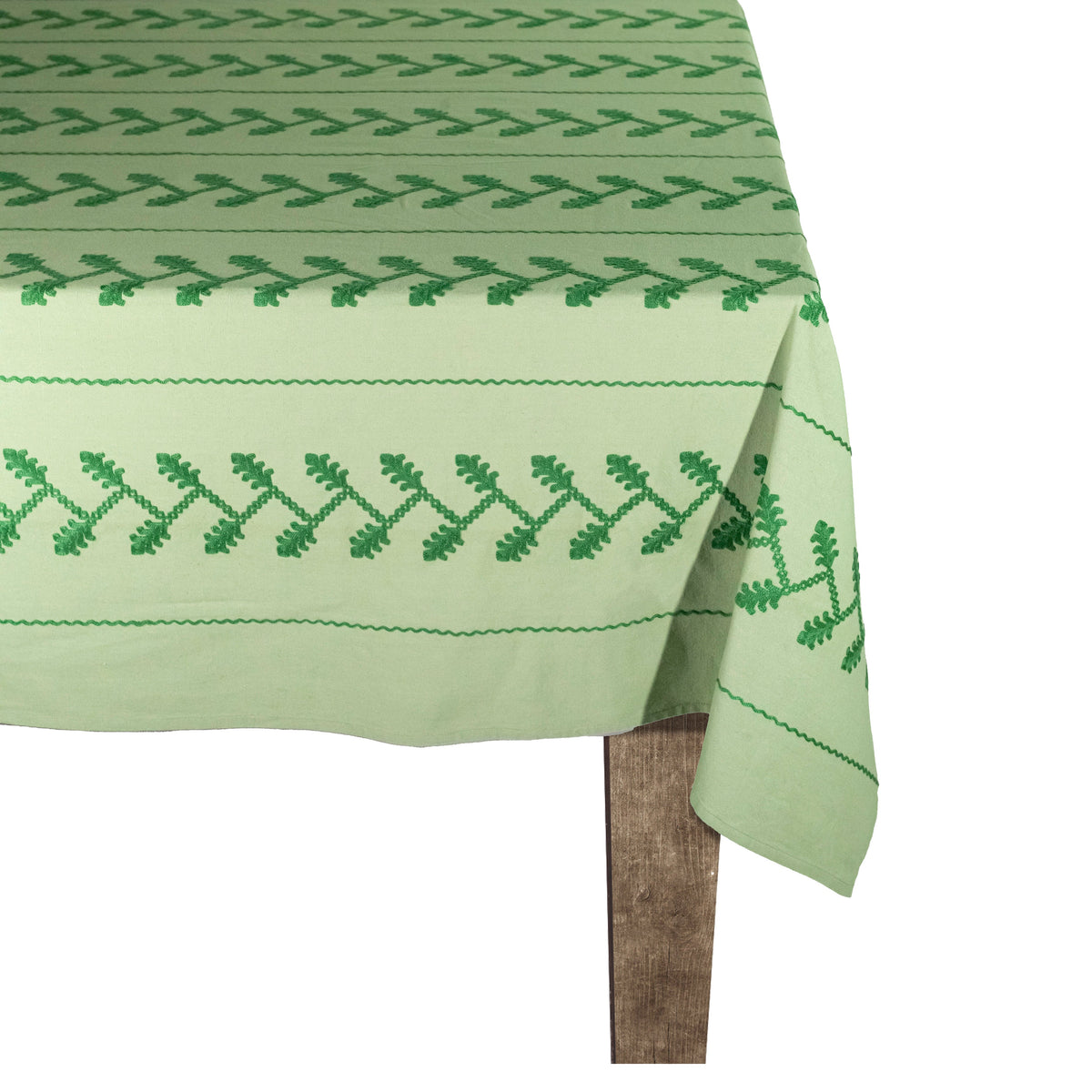Close-up of Tonal Green Vine Tablecloth showcasing embroidered green vine motifs on a white background