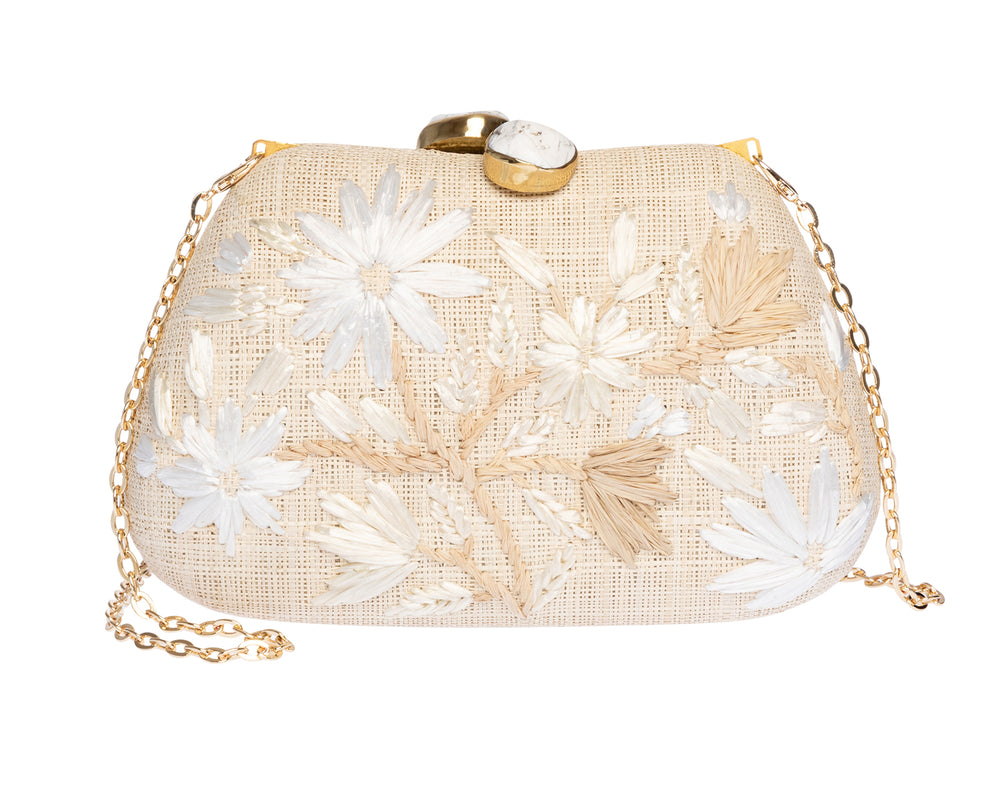 Front view of Tamu Clutch in Natural showcasing hand-embroidered white daisies, ivory stone clasps, and gold chain strap on white background