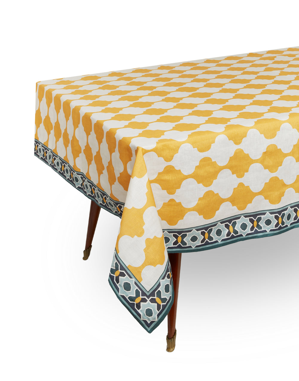 Three-quarter view of large rectangular tablecloth in Plaza yellow showing yellow-and-white trellis pattern and blue geometric border on white background