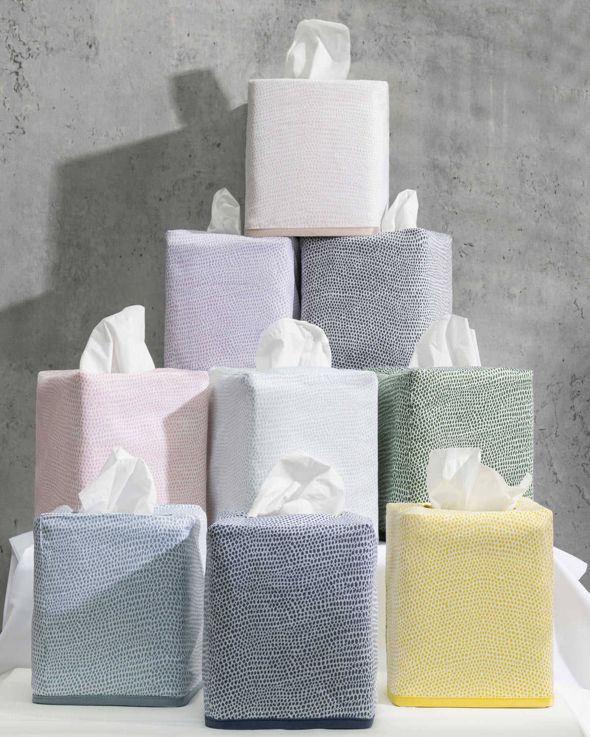 Stacked Jasper tissue box covers in assorted pastels showing shagreen-inspired textured sateen on a concrete background