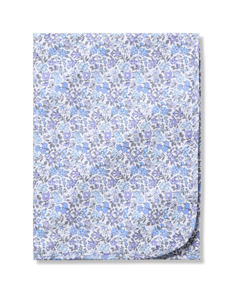 The Petite Plume Pima Baby Blanket in Fleur dAzur is crafted from soft Pima Cotton and showcases a vintage-inspired print of tiny blue and purple flowers on a white background.