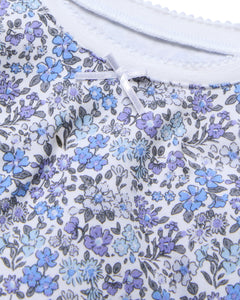 The Kids Pima Snug Fit Pajama Set in Fleur dAzur by Petite Plume features a vintage-inspired print with blue, purple, and gray flowers on white Pima cotton. A small white bow at the top center adds a delicate touch to the elegant fabric.