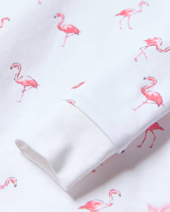 A close-up of soft Pima cotton fabric shows a playful pattern of small pink flamingos, part of Petite Plumes Kids Pima Snug Fit Pajama Set in Flamingo, perfect for a childs wardrobe.