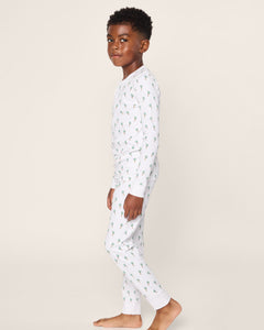 A young boy stands sideways on a white background, barefoot in Petite Plume’s Kids Pima Snug Fit Pajama Set in Palmier. The luxurious sleepwear features a cozy long sleeve top with a soft Pima cotton design adorned with small green cacti.