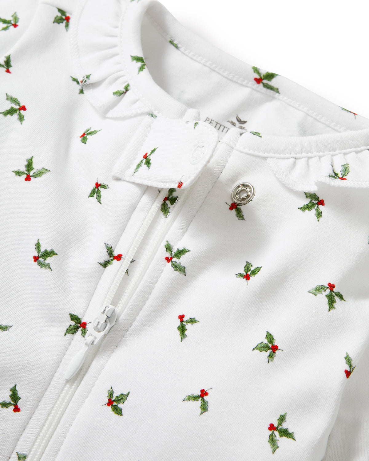 Close-up of Baby’s Pima Romper in Mistletoe Moments showcasing holly berry print, zipper, and snaps on white fabric