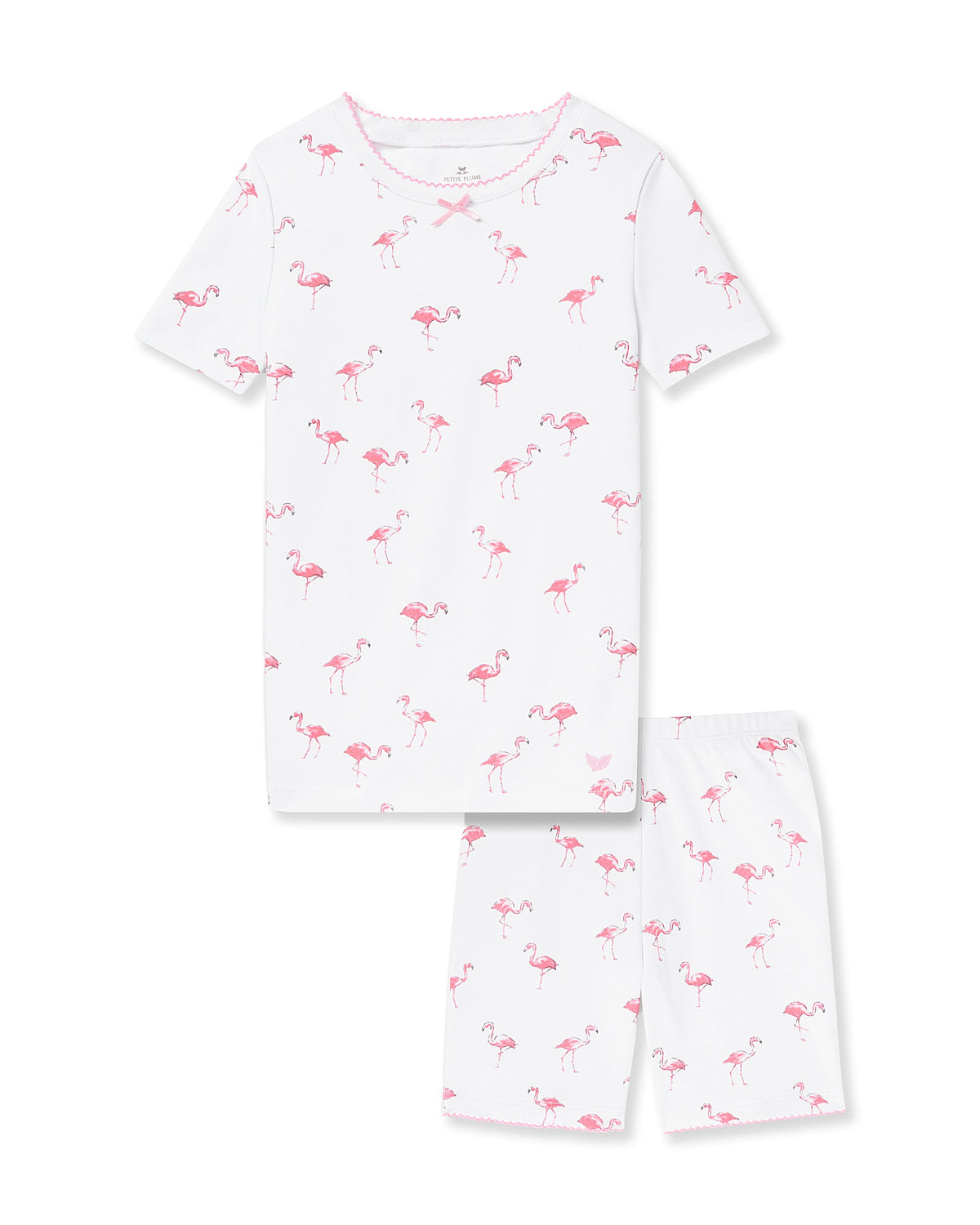 The Kids Pima Snug Fit Short Set in Flamingo by Petite Plume features a white, durable Pima cotton pajama set with a short-sleeved top and shorts, adorned with playful pink flamingos, ensuring comfort for little dreamers.