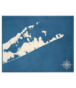 Blue blanket with cream-colored Hamptons map and compass rose design.