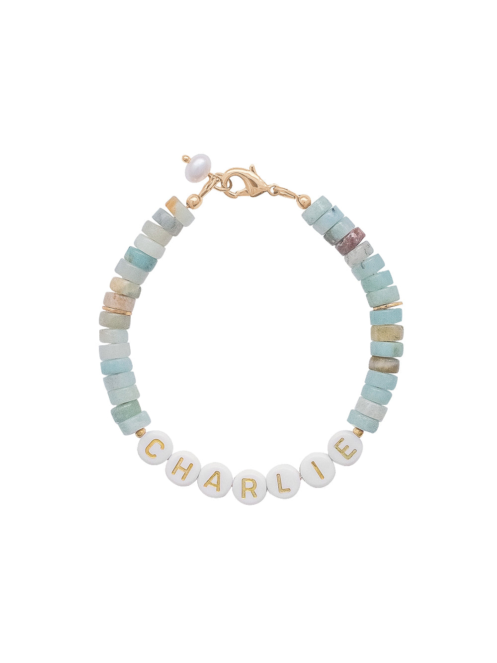 Top-down view of Tilly custom bracelet showing white letter beads spelling CHARLIE and pale blue heishi beads on white background
