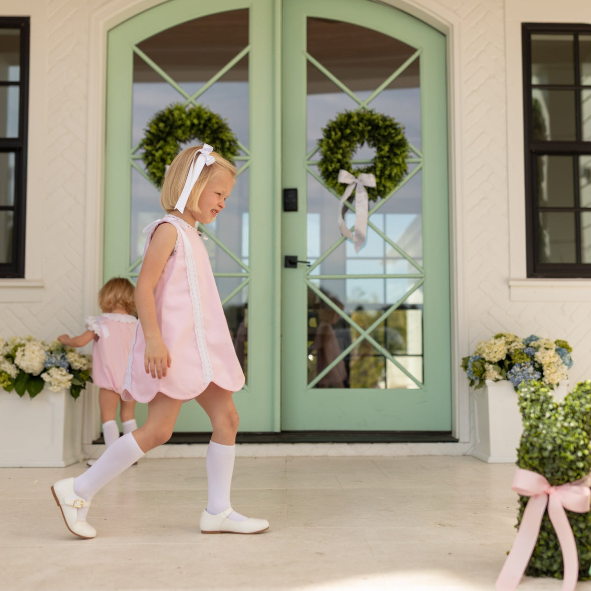 Girl wearing the Henry Duvall Rosie Dress, a classic pink girls dress designed for spring celebrations and family portraits.