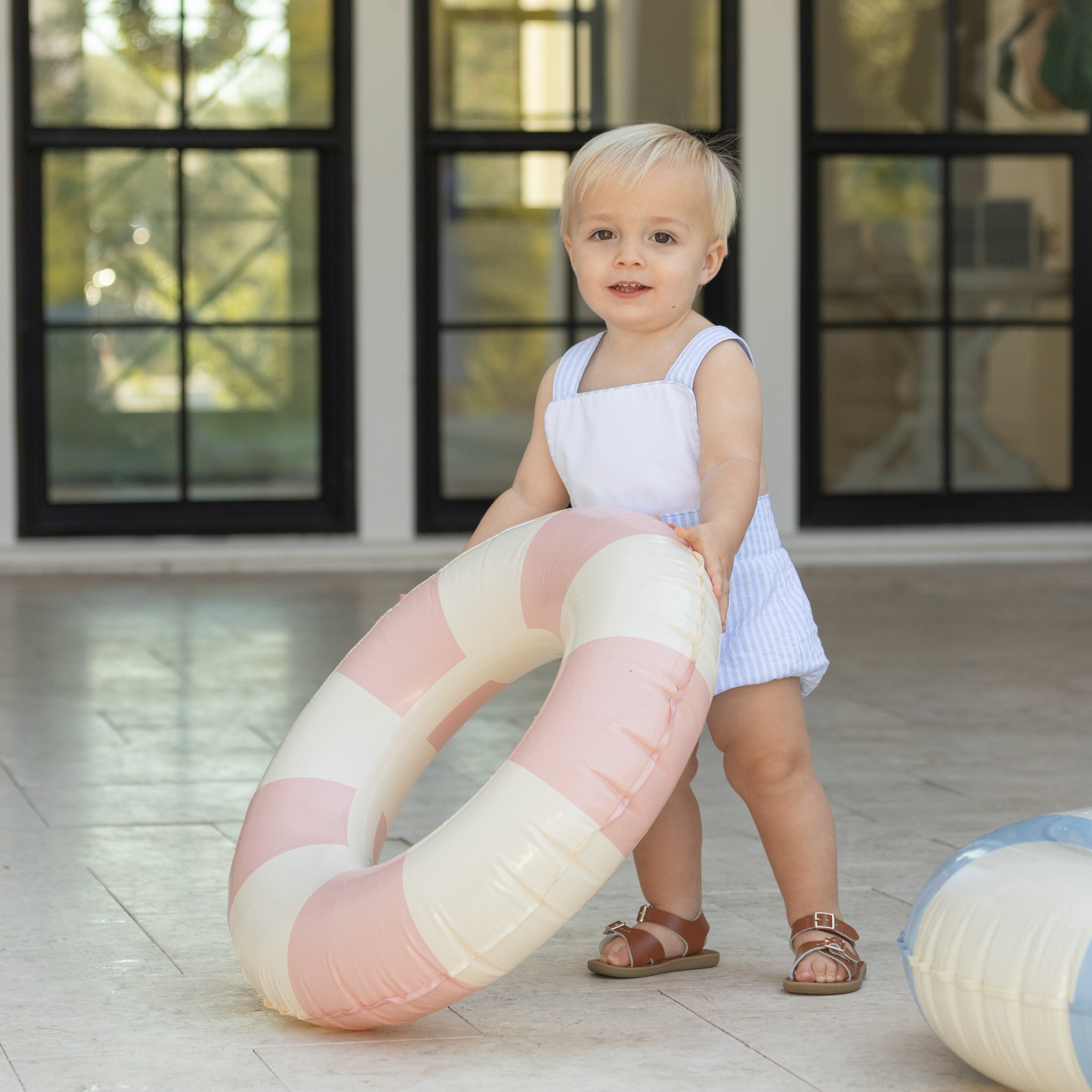 Baby boy wearing the Henry Duvall Henry Sunsuit in Seaside Stripe, a classic summer outfit designed for warm weather and sibling matching.