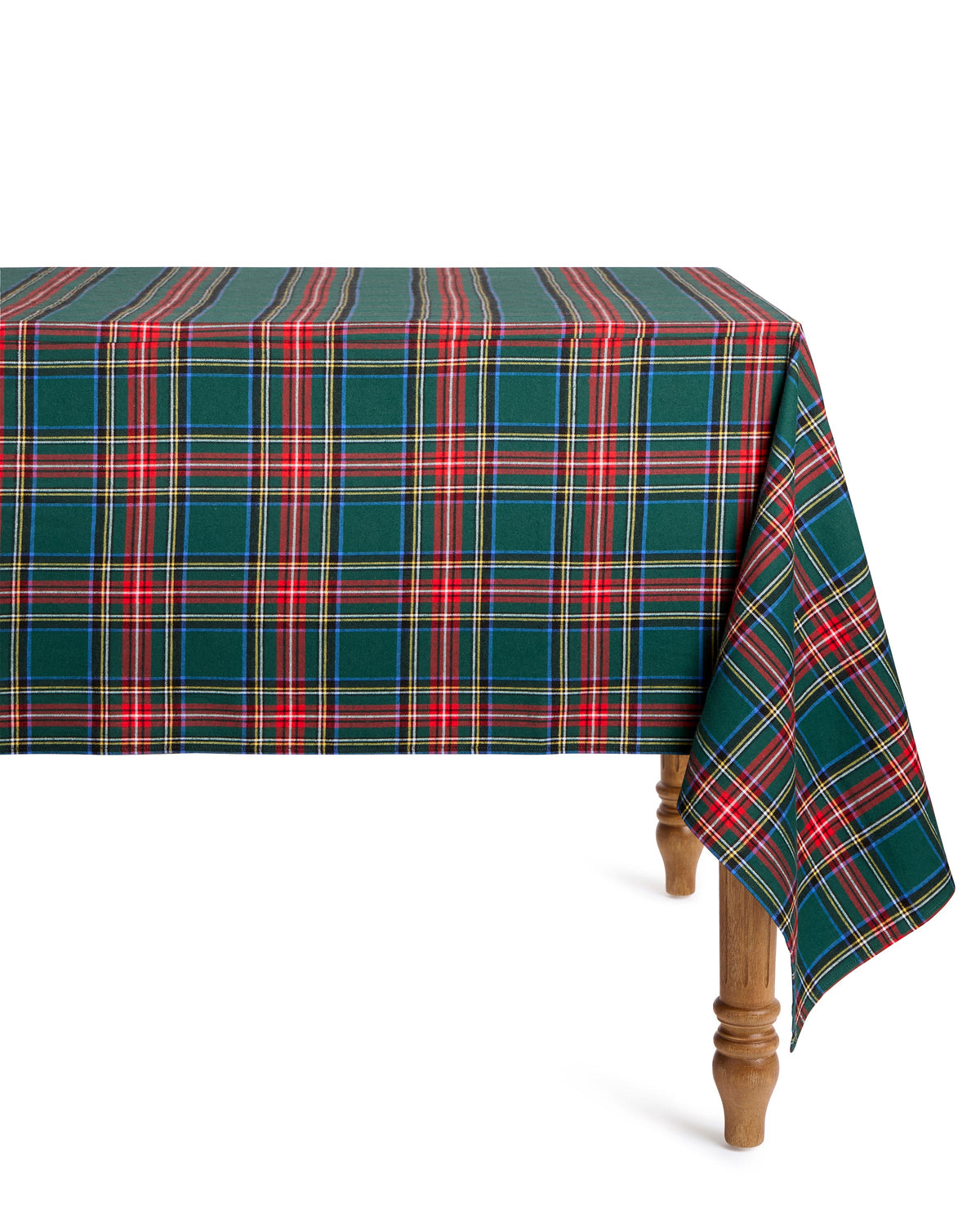 Angled view of Signature Twill Tablecloth in Kensington Tartan showcasing green plaid draped over a wooden table against white