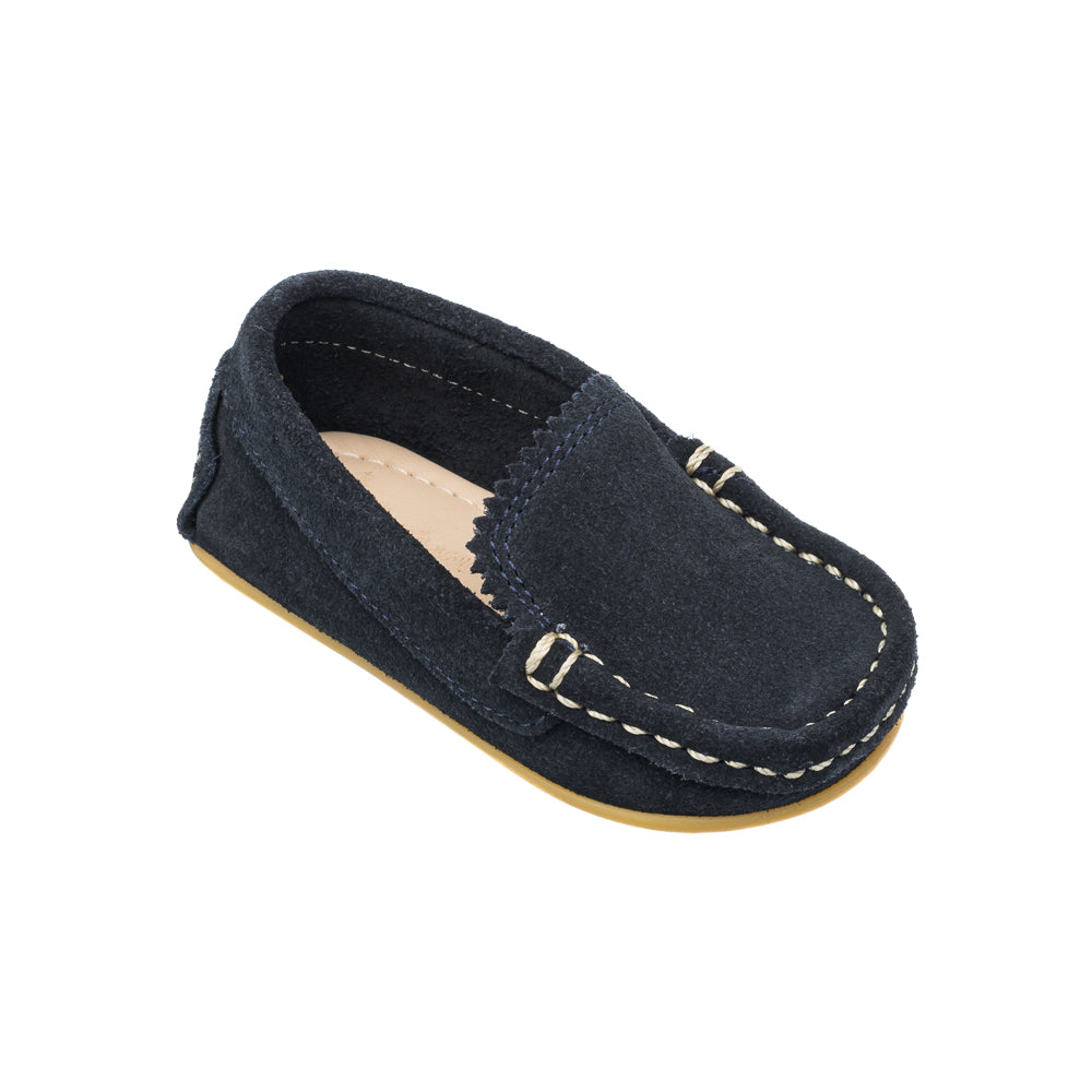 Angled view of Toddler Antton Driver Moc showcasing navy blue suede and hand stitched contrast seams on white background