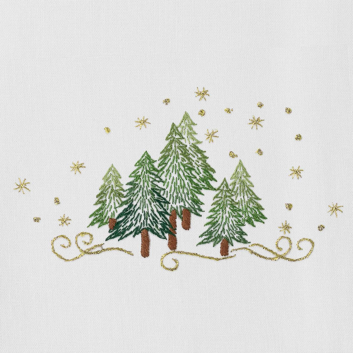 Close up of Pine Trees napkin showcasing hand embroidered green pine trees and gold star embroidery on white cotton